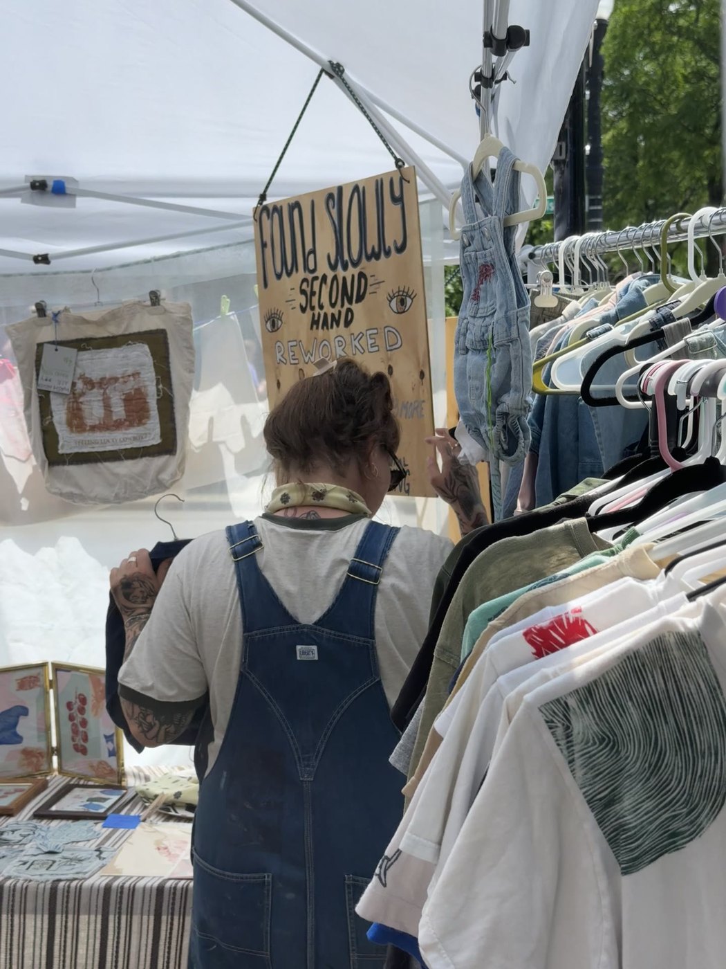 Found Slowly booth sign above garment racks